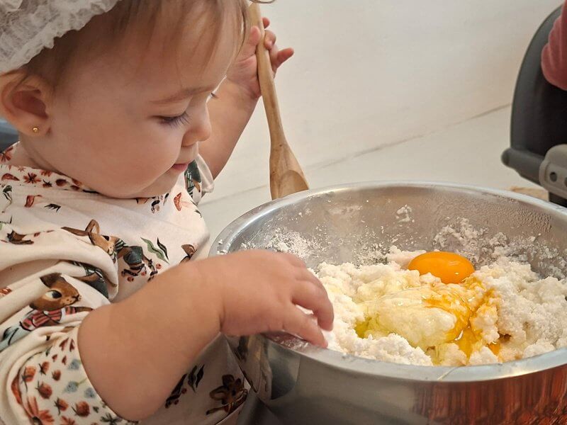 Criança mexendo uma massa com ovo em uma tigela